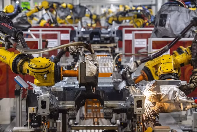 Các robot công nghiệp của Fanuc đến từ Nhật Bản được nhìn thấy trên dây chuyền sản xuất hoàn toàn tự động tại trụ sở sản xuất xe hơi khổng lồ của Đức, Volkswagen, tại Wolfsburg, miền bắc nước Đức - Ảnh: AFP / John MacDougall