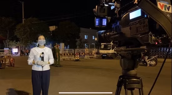 Phóng viên Hoàng Thuỷ cùng lực lượng công an trong đêm trắng lập chốt chặn dịch COVID-19. (vtv.vn)