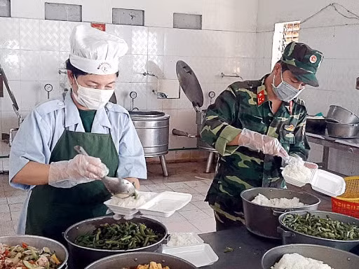 Các cán bộ chiến sĩ đang chuẩn bi thức ăn cho mọi người trong khu vực cách ly.