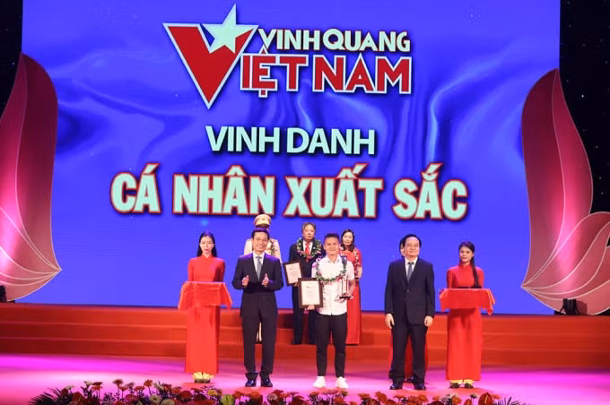 Bộ trưởng Bộ Thông tin & Truyền thông Nguyễn Mạnh Hùng và Bộ trưởng Bộ Giáo dục & Đào tạo Phùng Xuân Nhạ trao thưởng cho Danh thủ Quang Hải. Ảnh: laodong.vn