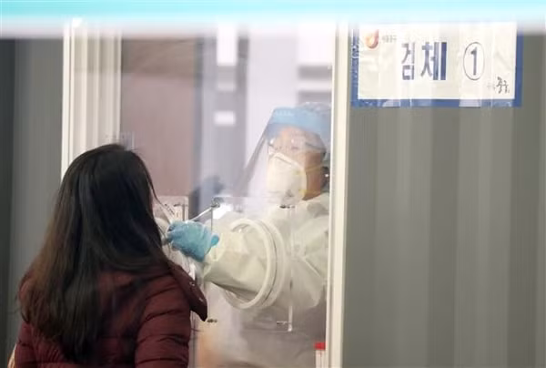 Nhân viên y tế lấy mẫu xét nghiệm COVID-19 cho người dân tại Seoul, Hàn Quốc, ngày 28/3/2021. Ảnh: Yonhap