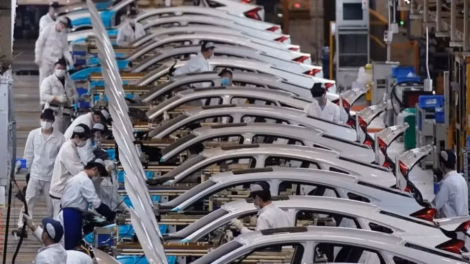Các nhân viên làm việc trên dây chuyền sản xuất bên trong nhà máy Dongfeng Honda ở Vũ Hán trước khi bị đóng cửa. © Reuters
