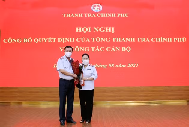 Tổng Thanh tra Chính phủ Đoàn Hồng Phong trao quyết định và tặng hoa chúc mừng tân Phó Tổng Biên tập phụ trách Báo Thanh tra Nguyễn Thị Hoa. Ảnh: PH