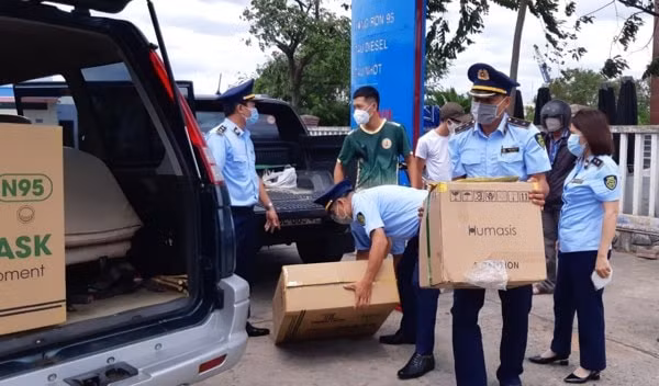 Lực lượng chức năng tạm giữ số khẩu trang, bộ kit test xét nghiệm nhanh COVID-19 không có giấy tờ hợp lệ. Ảnh: LĐO