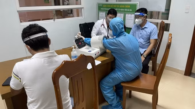 Các phóng viên được khám sàng lọc trước khi tiêm. Ảnh: Lưu Sơn