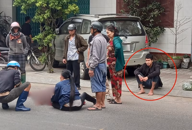 Nguyễn Văn Khôi ngồi bên lề phố cạnh nơi nạn nhân nằm gục