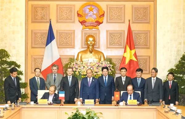 Bộ trưởng, Chủ nhiệm Văn phòng Chính phủ Mai Tiến Dũng (bên phải) và ông Jean-Pierre Marcelli, Giám đốc điều hành AFD ký kết Bản ghi nhớ hợp tác trước sự chứng kiến của Thủ tướng Nguyễn Xuân Phúc. Ảnh: VGP