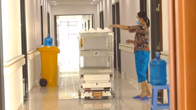 Robot VIBOT-2 vận chuyển đồ ăn đến từng phòng phục vụ bệnh nhân Covid-19 tại tầng 4 Zone 6 Bệnh viện Bạch Mai – Cơ sở 2, tháng 5/2021. Nguồn: Bộ KH&CN