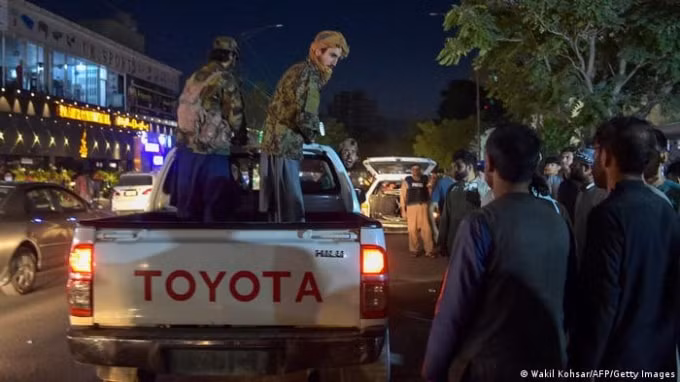 Các chiến binh Taliban quan sát mọi người trước bệnh viện khi tình nguyện viên chăm sóc những người bị thương. Ảnh: Getty
