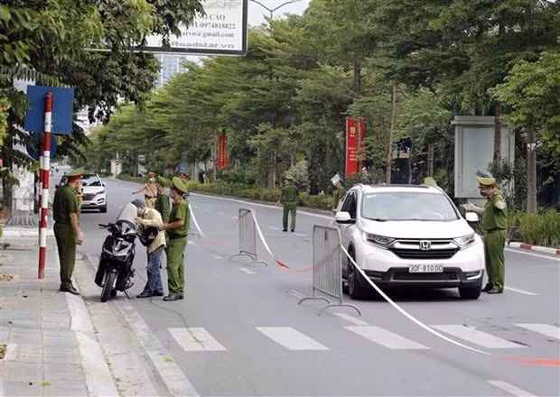 Lực lượng chức năng kiểm tra người đi đường trên phố Đào Tấn, quận Ba Đình. (Ảnh minh họa: TTXVN)
