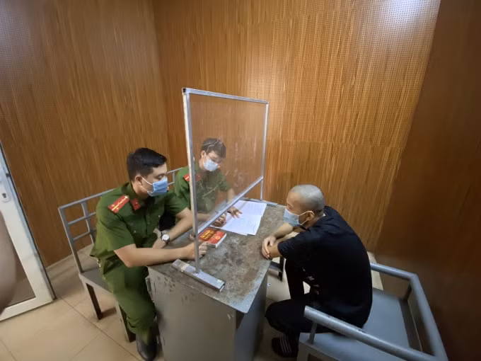 Công an huyện Đan Phượng thẩm vấn đối tượng dùng điếu cày tấn công lực lượng chức năng. Ảnh: CAHN