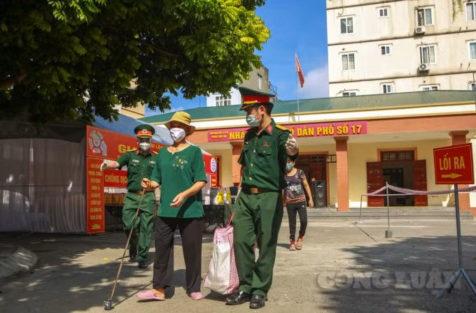 Lực lượng chức năng hỗ trợ mang quà ra xe và đưa về cho người dân.
