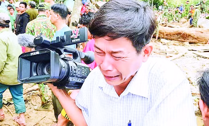 Bức ảnh nhà báo Đoàn Hữu Trung bật khóc tại hiện trường khi thấy hình ảnh thi thể cháu nhỏ trong lớp bùn đất khiến nhiều người không cầm được nước mắt. Ảnh: Hoàng Thế Lực.
