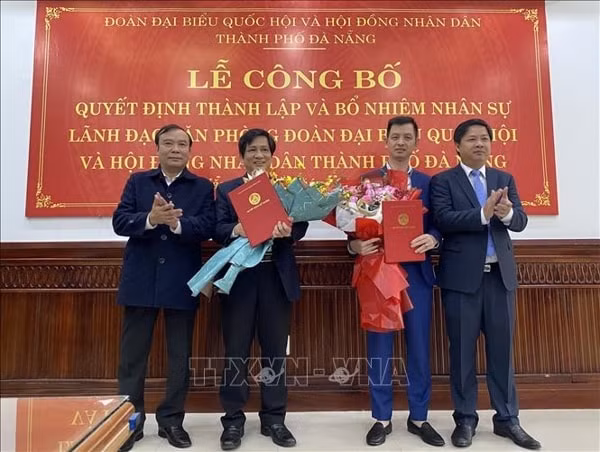 Ông Trần Văn Hấn, Chánh Văn phòng Đoàn đại biểu Quốc hội và HĐND thành phố (thứ 2 từ trái sang) và ông Nguyễn Thế Tuân, Phó Chánh Văn phòng Đoàn đại biểu Quốc hội và HĐND thành phố Đà Nẵng (thứ 3 từ trái sang) nhận Quyết định bổ nhiệm. Ảnh: TTXVN