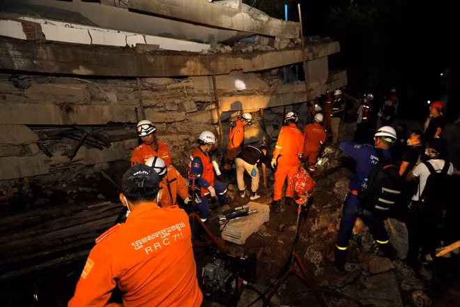 Lực lượng cứu hộ tìm kiếm những công nhân bị mắc kẹt trong đống đổ nát. Ảnh: Reuters