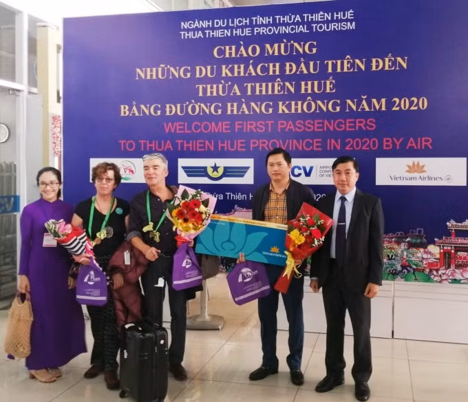Tặng hoa và tặng quà chúc mừng năm mới cho những vị khách đầu tiên đến Huế.