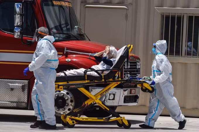 Nhân viên y tế chuyển bệnh nhân COVID-19 ở gần Miami, Mỹ ngày 30/7/2020. Ảnh: AFP/TTXVN.