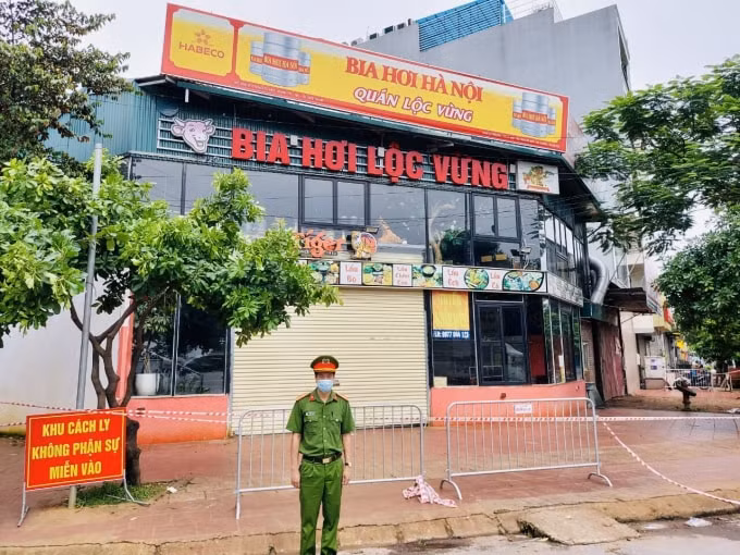 Lực lượng chức năng làm nhiệm vụ tại chốt kiểm soát y tế ở nhà hàng Lộc Vừng (nơi ca nghi mắc Covid-19 lưu trú). Ảnh: TL.