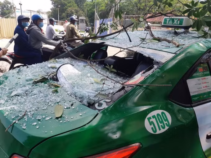 Chiếc taxi đỗ gần hiện trường bị hư hỏng. Ảnh: TL.