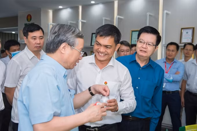 Tổng Giám đốc PVCFC Văn Tiến Thanh báo cáo với đồng chí Trần Quốc Vượng về tình hình đưa sản phẩm tới bà con