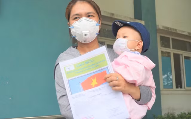 Bệnh nhi 8 tháng tuổi được trao giấy ra viện. Ảnh: TL.