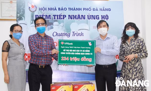 Ông Nguyễn Đức Nam, Chủ tịch Hội Nhà báo thành phố Đà Nẵng (thứ 2, từ phải sang), tiếp nhận 234 triệu đồng từ đại diện Ngân hàng VPBank khu vực miền Trung. Ảnh: Đắc Mạnh