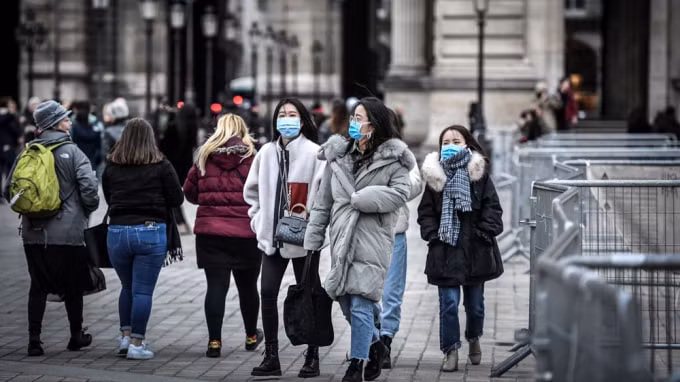 Người dân và du khách đeo khẩu trang phòng tránh lây nhiễm COVID-19 tại Paris, Pháp. Ảnh: TL