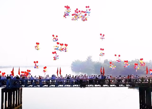 Đoàn đại biểu do Ủy viên Bộ Chính trị, Phó Thủ tướng Thường trực Chính Phủ Trương Hòa Bình dẫn đầu đứng giữa cầu Hiền Lương thả bóng bay, thể hiện ý nghĩa hợp nhất, thống nhất hai miền Nam, Bắc. Ảnh: Báo nhandan
