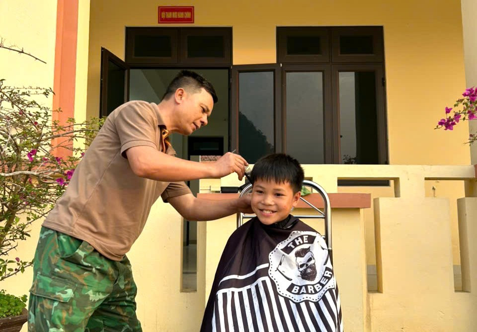 Từ những việc nhỏ như cắt tóc, "người lính quân hàm xanh" chăm lo cho “Con nuôi đồn Biên phòng” như những người thân trong gia đình. Ảnh: BĐBP Lào Cai. 65.jpg
