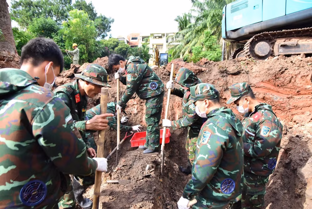 Lực lượng chức năng tìm kiếm, quy tập hài cốt liệt sĩ tại Khu B, Công viên Lê Thị Riêng. Ảnh TTXVN.