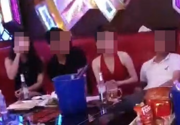 Các cán bộ nhậu và hát karaoke có tiếp viên nữ phục vụ “rót bia”. (Ảnh từ clip)