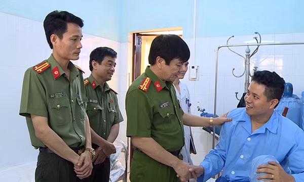 Đại tá Khương Duy Oanh (giữa) thăm hỏi, động viên chiến sỹ công an bị thương trong quá trình phá án. Ảnh: CATH