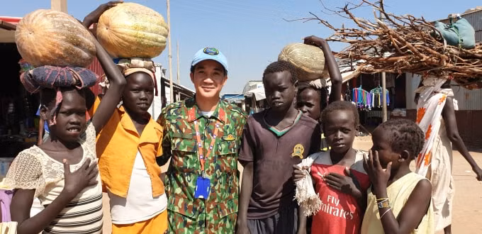 Nhà báo Vũ Hùng chụp ảnh cùng trẻ em ở Bentiu trong chuyến tác nghiệp tại Nam Sudan. Ảnh: Trương Tuấn