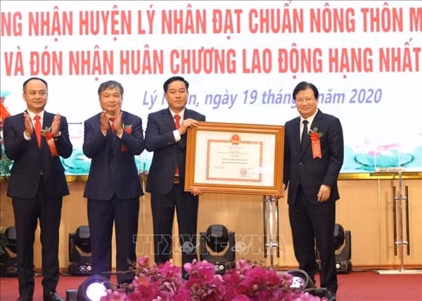 Phó Thủ tướng Trịnh Đình Dũng trao Bằng công nhận huyện Lý Nhân đạt chuẩn nông thôn mới năm 2019. Ảnh: TTXVN