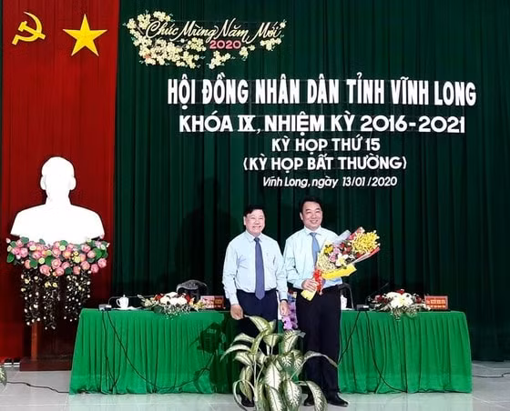 Ông Trần Văn Rón, Bí thư Tỉnh ủy Vĩnh Long (bên trái) tặng hoa chúc mừng ông Lữ Quang Ngời. Ảnh: SGGP