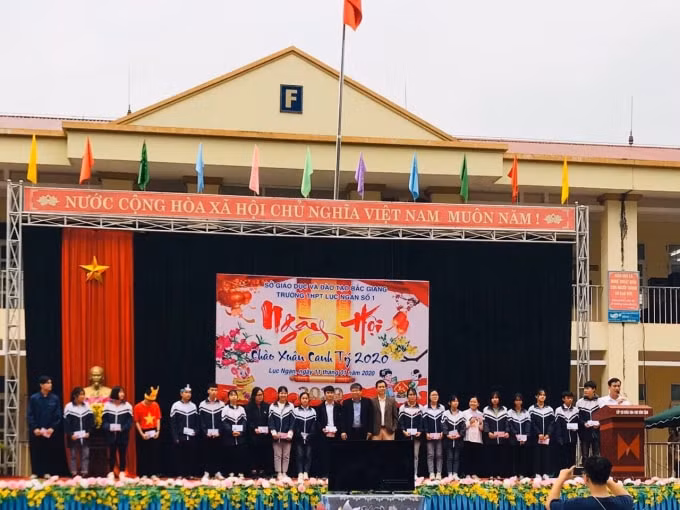 Thầy Hiệu trưởng Ngô Quang Khải và đại diện Hội Phụ huynh học sinh trao học bổng cho các em có hoàn cảnh khó khăn, vươn lên trong học tập. Ảnh: Thuỷ Tiên