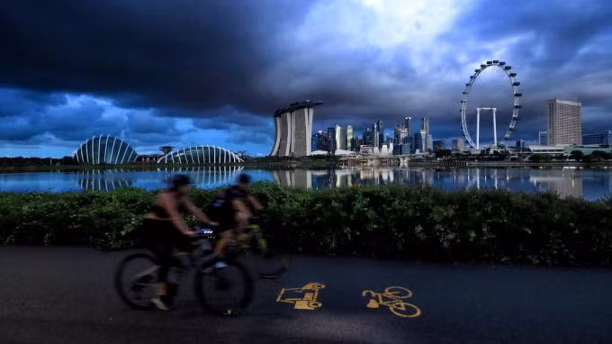Người đi xe đạp đi qua đường chân trời của thành phố ở Singapore vào ngày 19 tháng 6: điều chỉnh cơ sở hạ tầng đường bộ hiện có để thân thiện hơn với xe đạp sẽ là một hệ quả đáng hoan nghênh của đại dịch. Ảnh: Getty