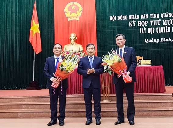 Bí thư Tỉnh ủy Quảng Bình Vũ Đại Thắng tặng hoa chúc mừng tân Chủ tịch UBND tỉnh (bên phải) và tân Chủ tịch HĐND tỉnh Quảng Bình (bên trái)